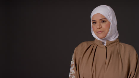 Studioporträt-Einer-Muslimischen-Frau-Mit-Hijab-Vor-Schlichtem,-Dunklem-Hintergrund-1
